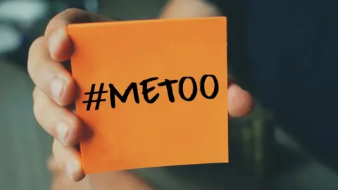 Getty Images #MeToo hashtag being held up on notepad