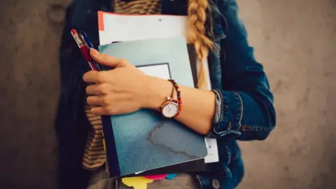 Getty Images Student holding folders