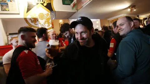 PA Media Paul Rudd holding a pint and smiling in the pub