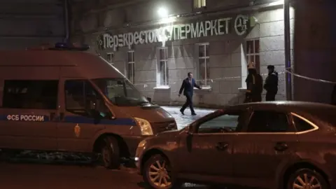 Reuters A vehicle (left) of the Russian Federal Security Service (FSB) is parked near a supermarket after an explosion in St Petersburg, Russia, 27 December 2017.