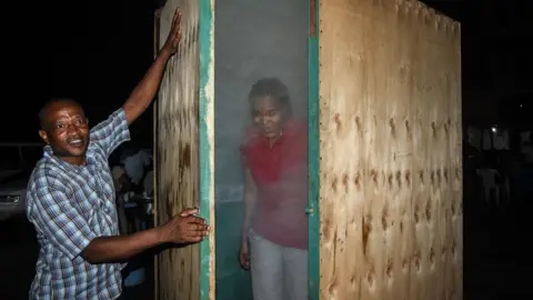 Getty Images A woman coming out of a steam inhalation booth installed in Dar es Salaam