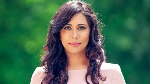 Woman in pink top with dark hair