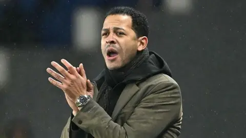 Liam Rosenior clapping on the touchline while managing French club Strasbourg