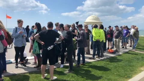 A queue of people in Bexhill, waiting to clean the artwork