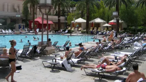 PA Rows of sunbeds by a pool