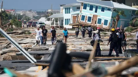 Getty Images Mexico Beach residents walk down a street on Thursday