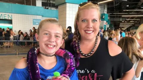 Family handout A younger Cali smiling at the camera with her mum, Mindy