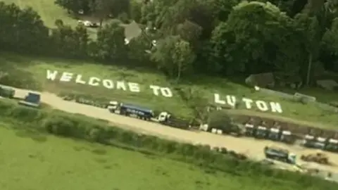 Abbey Desmond Welcome To Luton Sign at Gatwick Airport