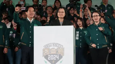 Getty Images Taiwan's President Tsai Ing-wen (C), President-elect Lai Ching-te (L) and his running mate Hsiao Bi-khim attend a rally outside the headquarters of the Democratic Progressive Party (DPP) in Taipei