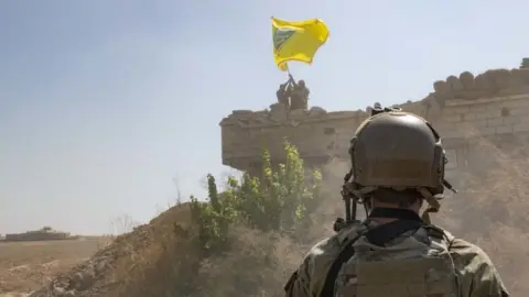 EPA US soldier looks at SDF troops dismantling YPG outpost, September