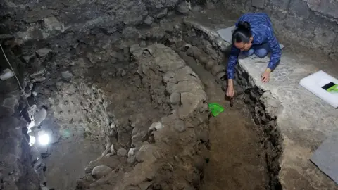 Reuters Lorena Vazquez, an archaeologist from the National Institute of Anthropology and History (INAH), works at a site where more than 650 skulls caked in lime and thousands of fragments were found in the cylindrical edifice near Templo Mayor, one of the main temples in the Aztec capital Tenochtitlan, which later became Mexico City, Mexico June 30, 2017