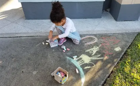 Candace Shultis Girl drawing outside the MMC church