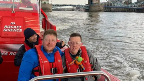 FAMILY HANDOUT Mr Russell-Pierce on a speed boat with his brother on the Thames