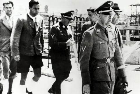 Galerie Bilderwelt/Getty Images Heinrich Himmler (1900 - 1945, foreground right) and Chief Engineer Max Faust (far right) during Himmler's visit to the Monowitz-Buna plant (Auschwitz III) at Auschwitz, Poland, July 1942. (Photo by Galerie Bilderwelt/Getty Images)