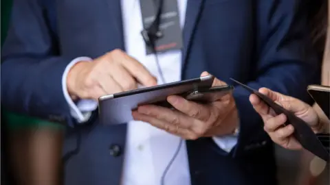 Getty Images Man checks Covid certificate on iPad