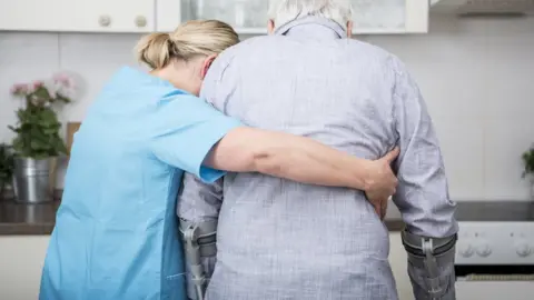 Getty Images Carer supports man