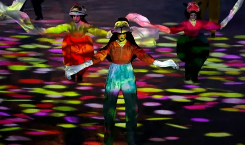 Reuters Artists perform with circles of coloured lights around them