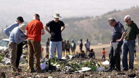 Getty Images Investigators with the US National Transportation and Safety Board look at debris from the crash site of Ethiopian Airlines Flight ET 302