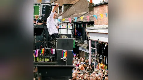 Outside Organisation/PA Wire Singer Nick Cave plays a show with his band on the roof of a record shop in Brighton. The street below is swamped with fans. 