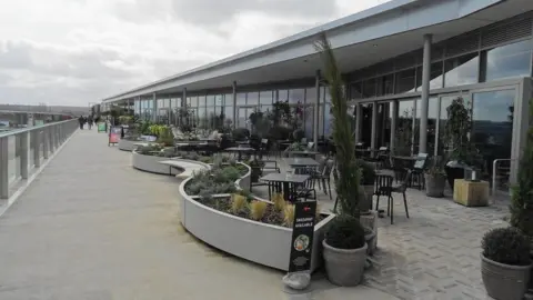 John M An upper level outdoor walkway beside restaurants at the Westgate shopping centre