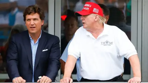 Getty Images Tucker Carlson with Donald Trump in July 2022