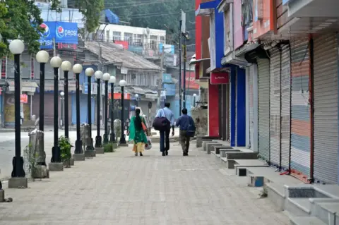 Getty Images Indian tourists seen leaving the City during the curfew in Srinagar on 16 August 2019.