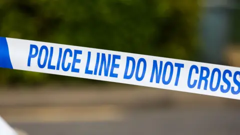 Getty Images Close up of police tape with blue lettering saying 'Police do not cross'