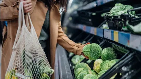 Getty Images Woman shopping for groceries