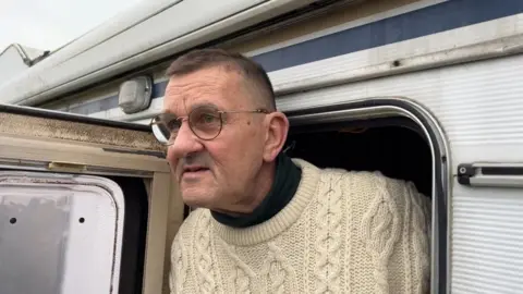 ANDREW TURNER/BBC David Young looking out from the door of his camper van.
