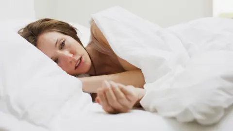 Getty Images Sick woman with flu lying in bed