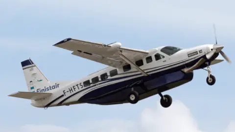 A blue and white Finistair aircraft in flight