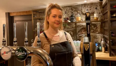 Lacey-Mae at work behind a bar