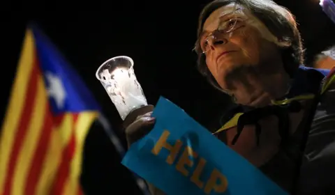 Getty Images A woman holds a candle during a demonstration in Barcelona against the arrest of two Catalan separatist leaders, 17 October 2017