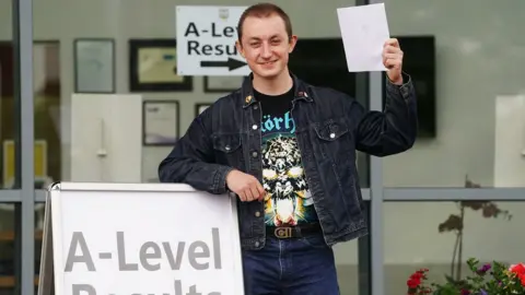 Brian Lawless/PA Drew Totton celebrates after receiving his A-level results at Lagan College, Belfast.