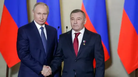 Tass via Getty Images Russia's President Vladimir Putin (L) awards a Russian Hero of Labour gold star to Stroygazmontazh owner Arkady Rotenberg