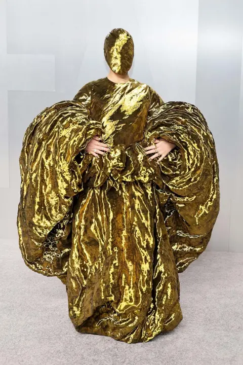 Getty Images Audrey Nuna in gold dress with matching face mask