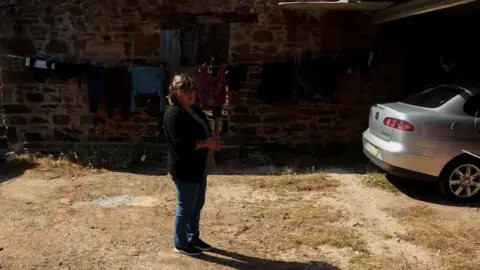 Lídia Antunes, saved 2 people from death in her grey Seat. She stands in the middle of her yard