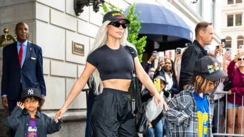 Getty Images Kim Kardashian with Saint (right) and Psalm