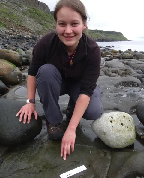 Stephen Brusatte PhD student Amelia Penny points to the fossil she discovered