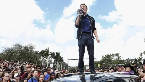 Getty Images Cameron Kasky standing on a car