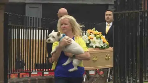 BBC Emma Faulds' West Highland terrier Maverick leads the procession out of the church