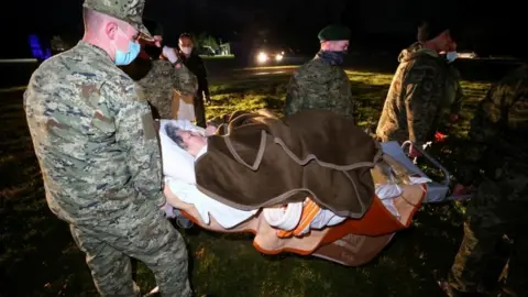 Reuters Military personnel carry an ill person on a stretcher to be evacuated to Zagreb by helicopter