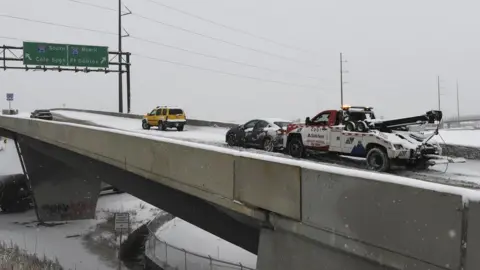 Getty Images A tow truck pushes a car up the ramp in Denver