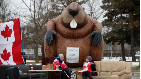 Getty Images Protestors and supporters sit at a blockade at the foot of the Ambassador Bridge