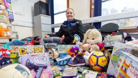 West Midlands Police PCSO Kate Sephton surrounded by the gifts