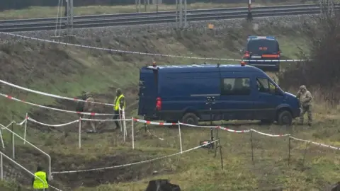 WOJTEK JARGILO/EPA/Shutterstock Special forces and police investigate at the scene of a destroyed section of railway tracks on the Deblin-Warsaw route near the Mika railway station, central Poland, 17 November 2025