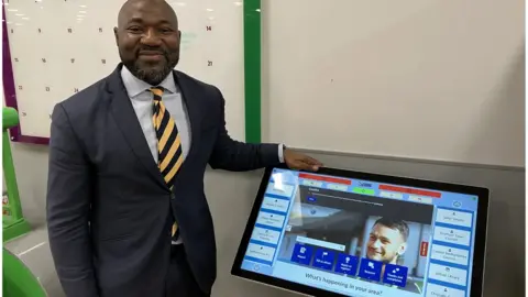 Sam Read/BBC Festus Akinbusoye smiling with one of the terminals