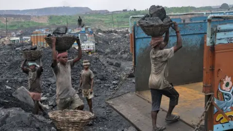 Getty Images This photo taken on December 7, 2017 shows Indian labourers loading coal onto trucks at an open mine in Dhanbad in the eastern Indian state of Jharkhand.