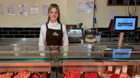 Judith Jacobs Lottie Mallia behind the butcher's counter