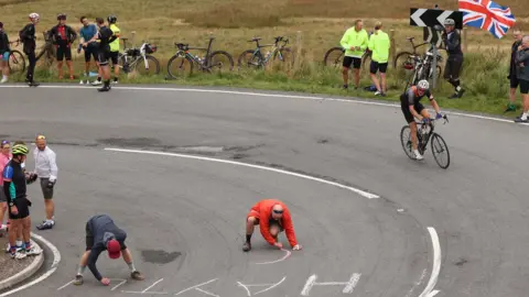 Reuters Spectators write a message on the road at Hartside Pass in Alston